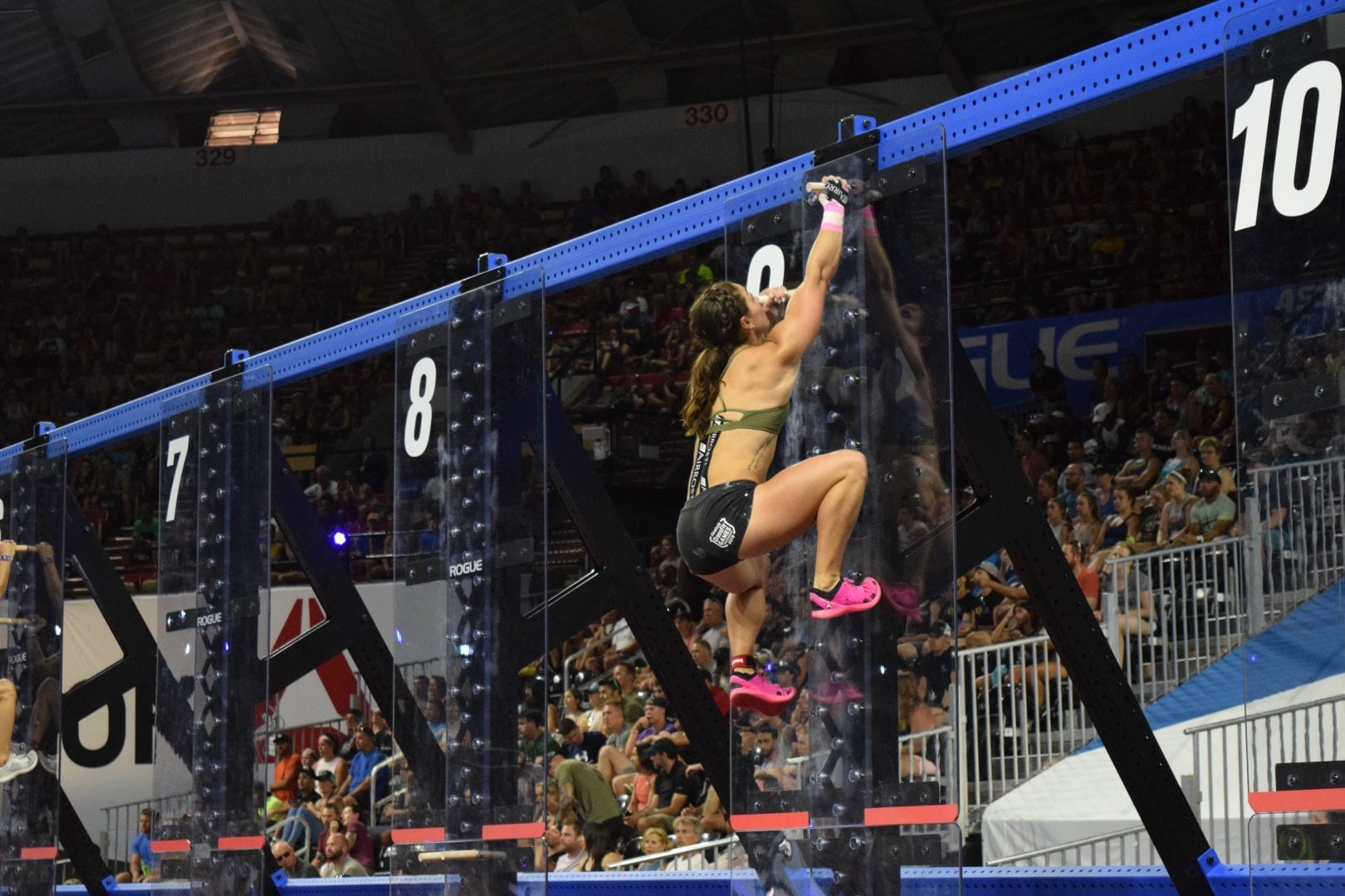 Bethany Shadburne climbs pegboards in the coliseum at the 2019 CrossFit Games.