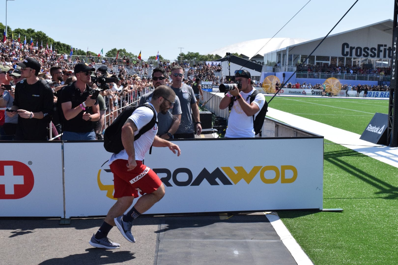 Mat Fraser nears the finish line of the Ruck Run event at the 2019 CrossFit Games. He would receive a penalty for dropping a weight as he rounded one of the last corners.