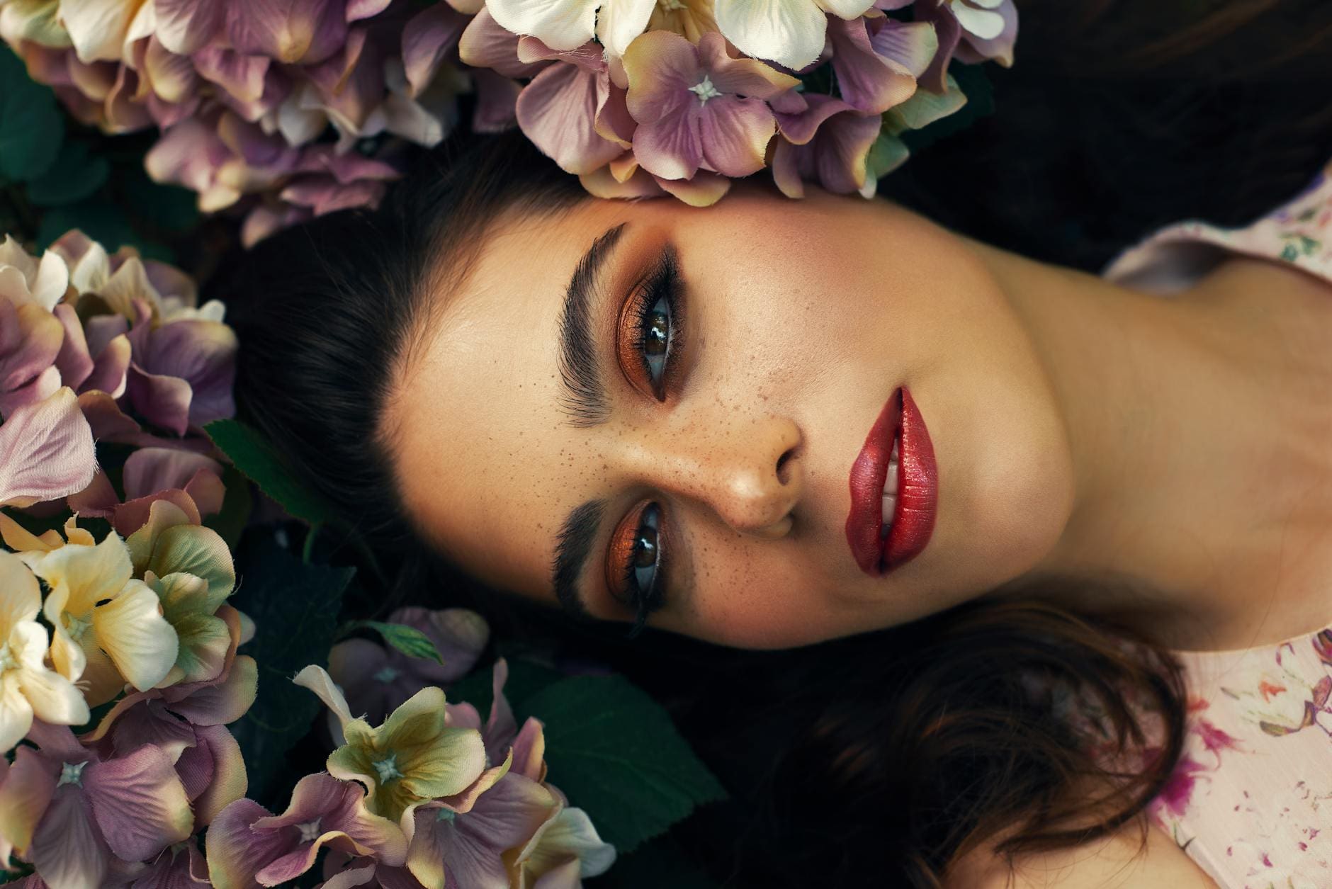 woman with red lipstick surrounded with flowers