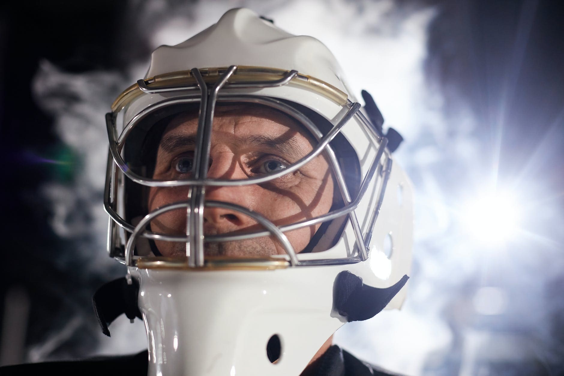 close up shot of man wearing a hockey helmet