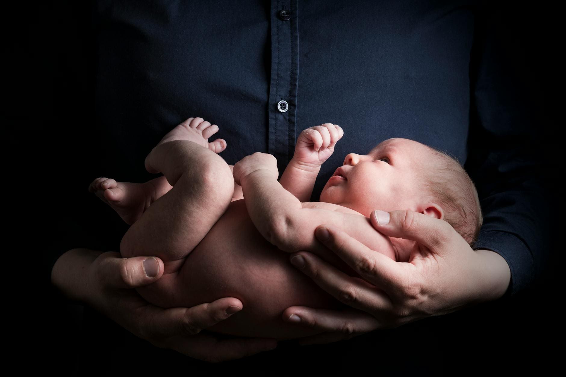 close up photo of a person carrying a baby